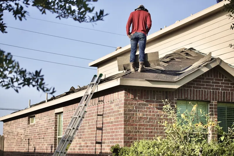 Professional roofer working on a residential roof in Booth-Boyd